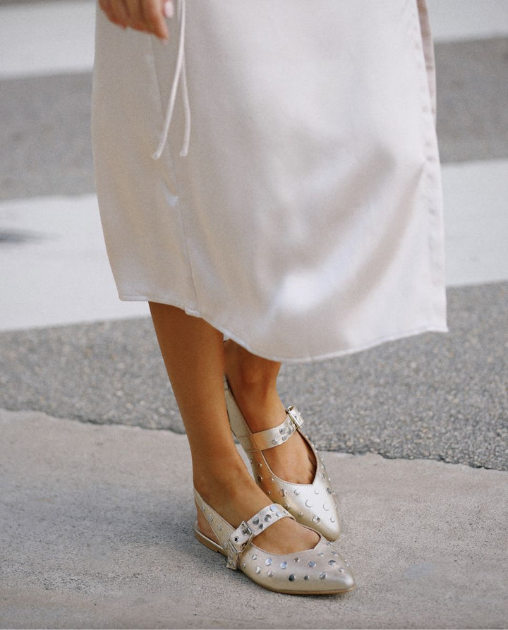 vestido blanco largo con sandalias color champagne con tachuelas
