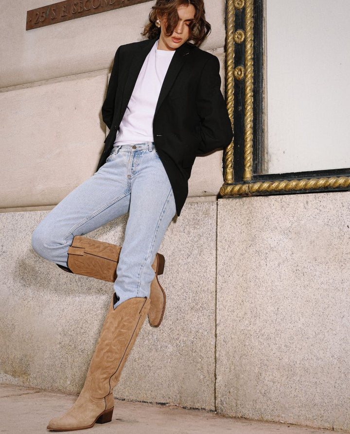 Mujer con jeans y botas texanas altas en ante marrón