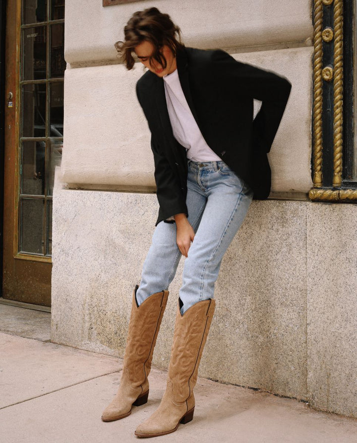 Mujer con jeans y botas texanas altas en ante marrón