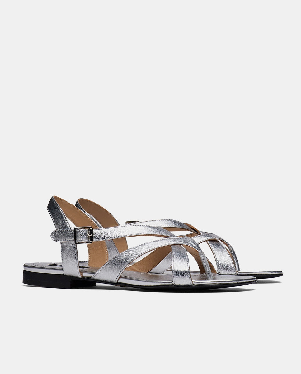 par de sandalias color plata planas con tiras