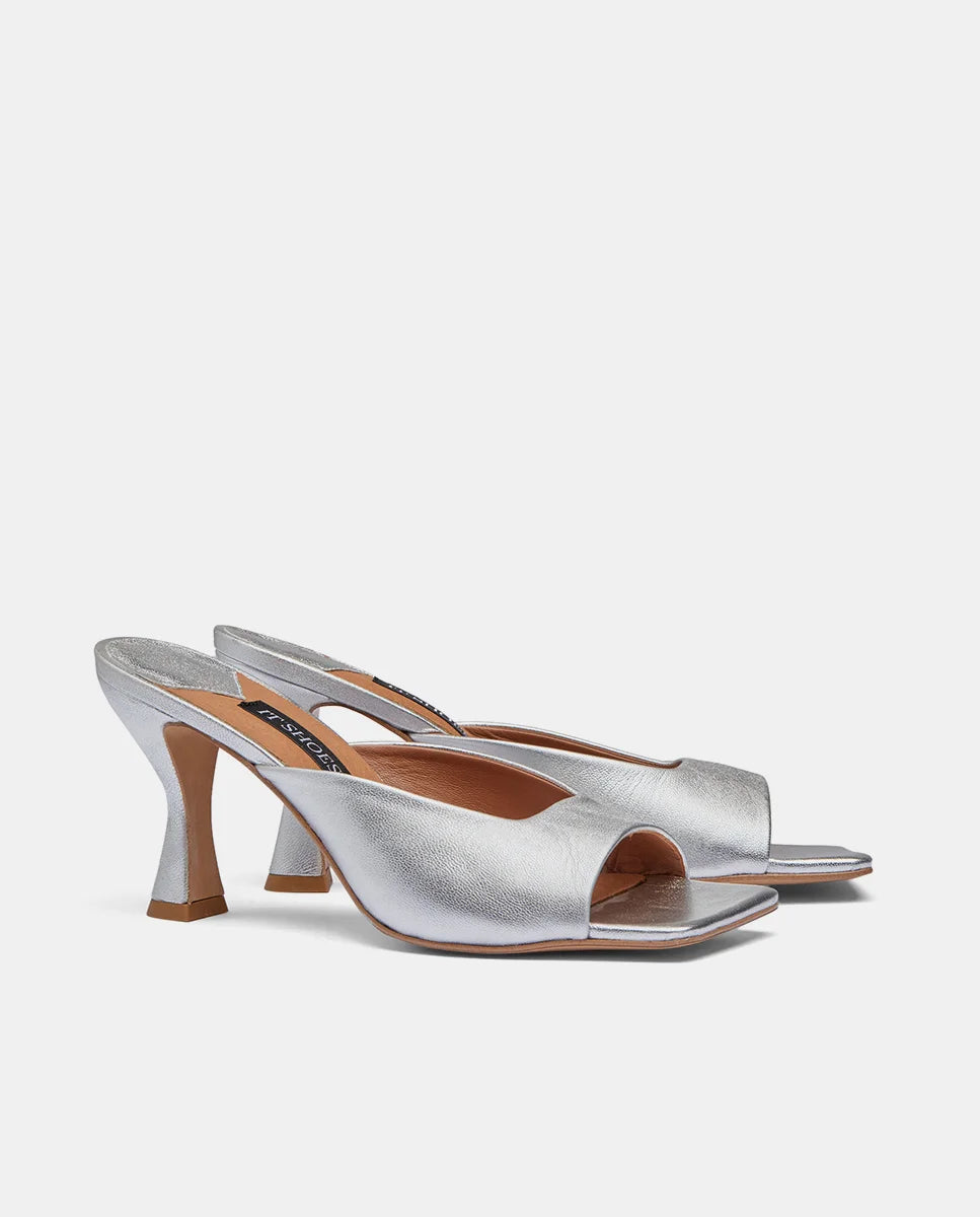 Lateral de sandalias plateadas con tacón hechas en cuero