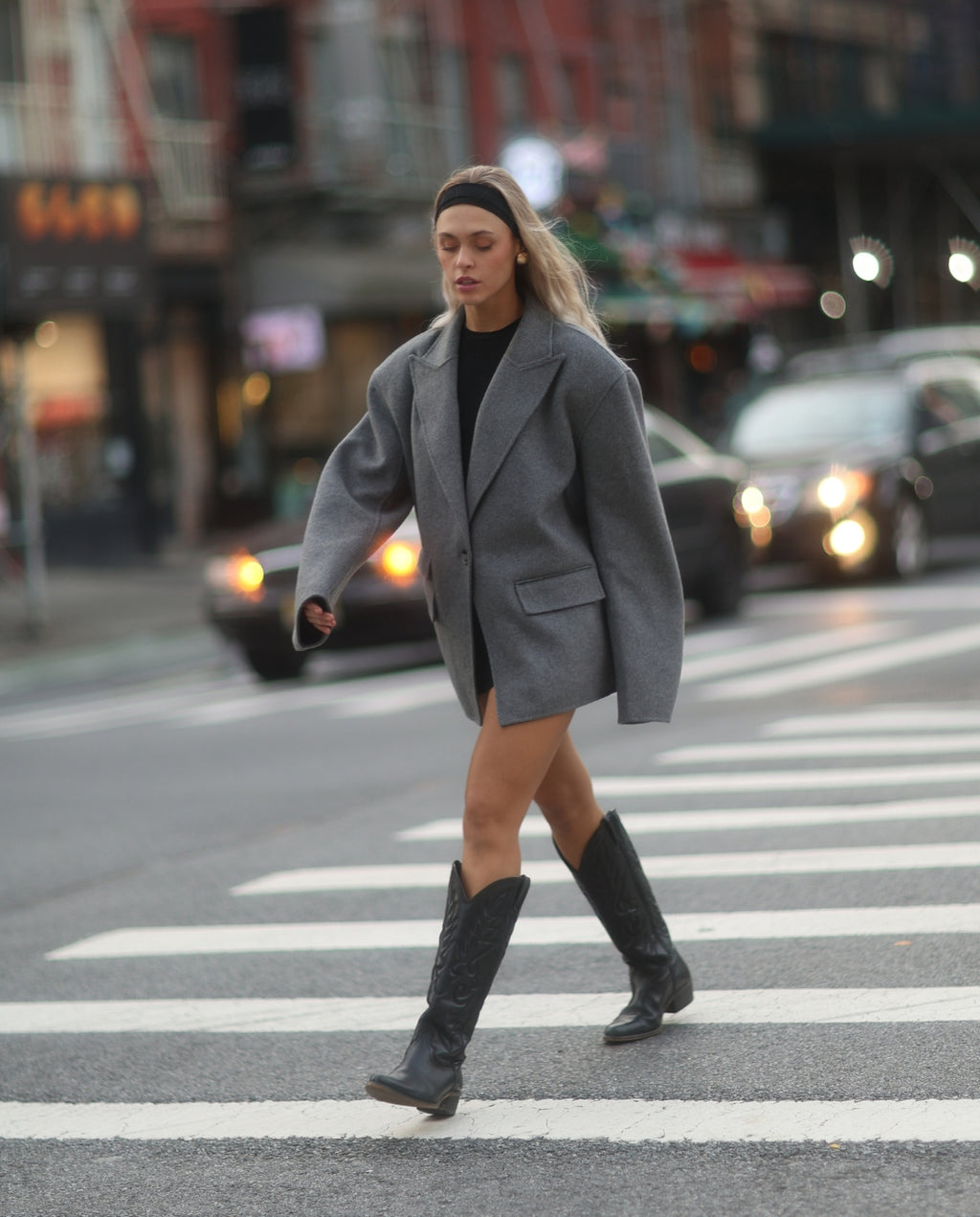 Mujer con traje gris y botas cowboy negras altas para mujer