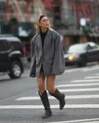 Mujer con traje gris y botas cowboy negras altas para mujer
