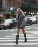 Mujer con traje gris y botas cowboy negras altas para mujer