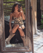 Look con botas cowboy en ante media caña marrón y vestido de flores
