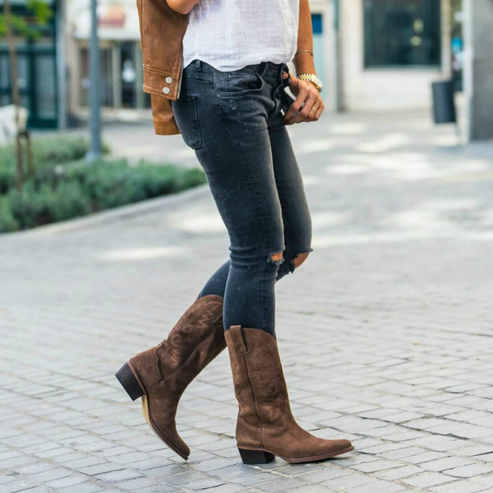 Look de botas texanas marrones con jeans rotos por la rodilla mujer media caña
