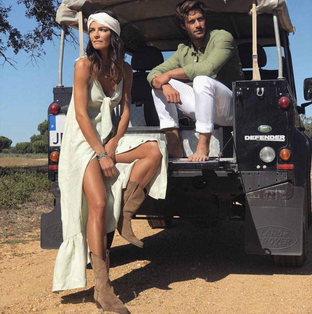 Mujer con botas camperas color taupe y vestido blanco largo