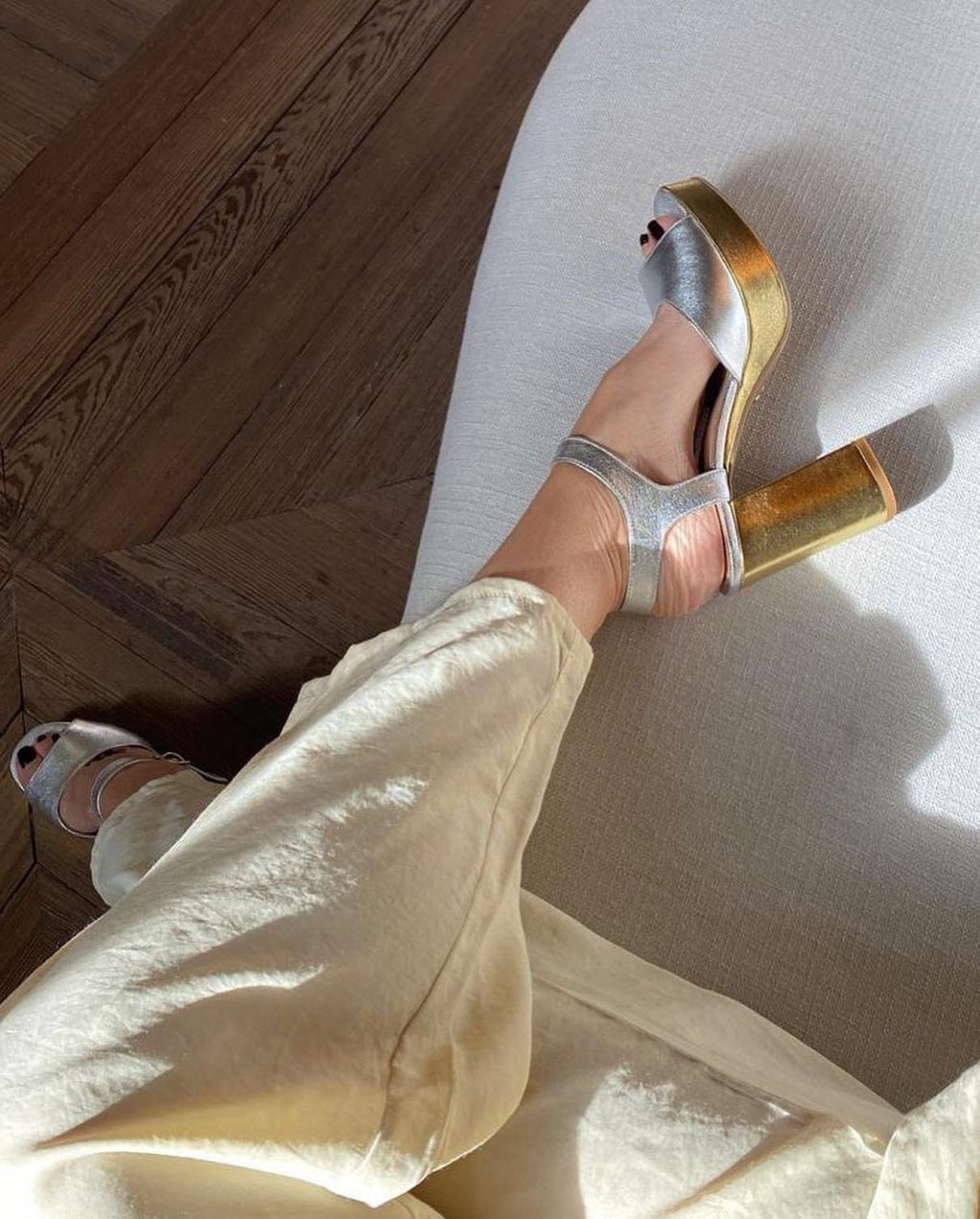 Sandalia con tacón dorado y puntera plateada con pantalón